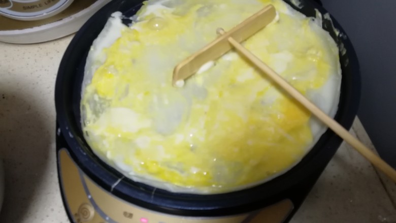 黑胡椒煎饼果子,把鸡蛋捣碎,涂抹均匀
