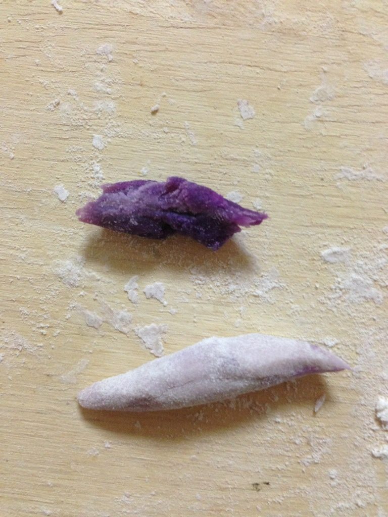 紫薯花卷,把一个小挤子一分为二,揪出一半包住紫薯泥后搓成梭形,或直接把紫薯泥搓成梭形,用来做花心;