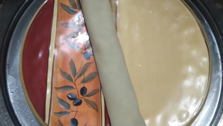 颜值与美味并存的――千张鸡肉卷,将千张卷起,放盘,入锅。