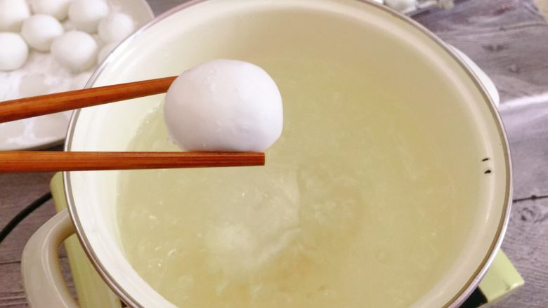 韭菜肉馅汤圆,锅中煮开水,把汤圆一个一个放入。