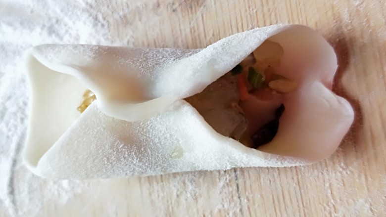 西葫芦\虾仁\胡萝卜\香菇\四喜蒸饺,先对折捏紧,如图所示。