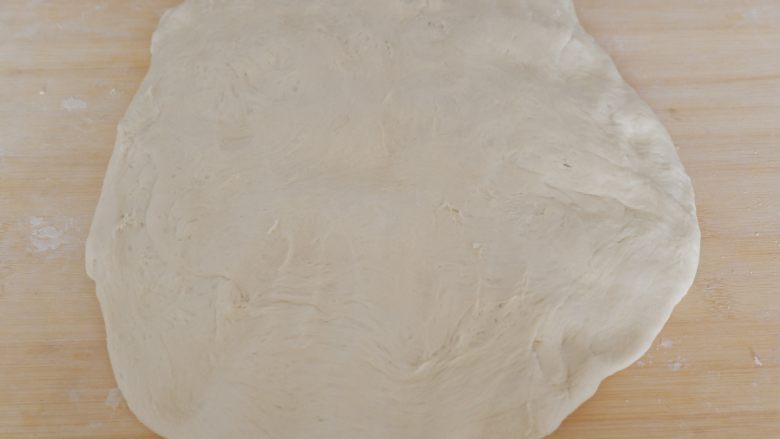 圆白菜虾皮素包子,案板上撒少许干粉,将面团取出按压排气。