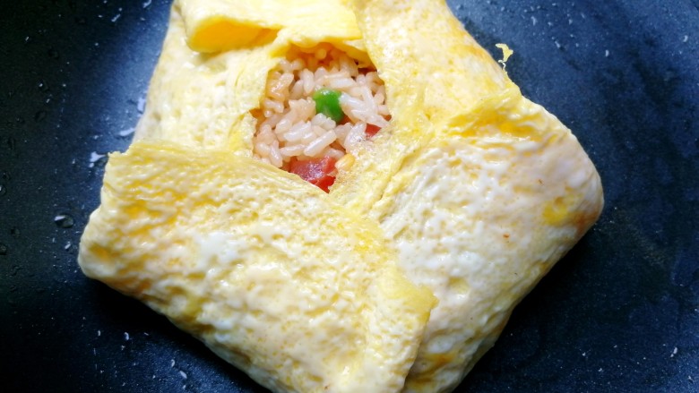 蛋包饭,然后按照这样,把米饭包起来,拿个盘子盖上去,左手托住盘子,右手把平底锅反转过来