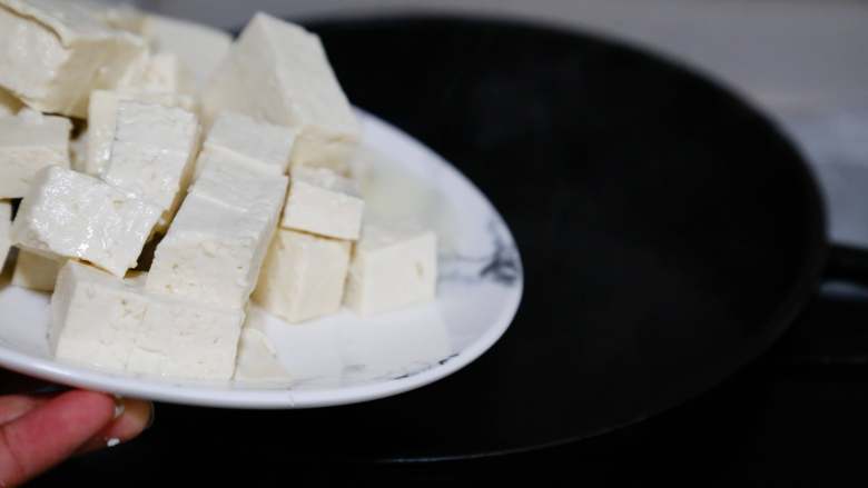 麻婆豆腐,勺一锅水，水开后放入切好的豆腐。