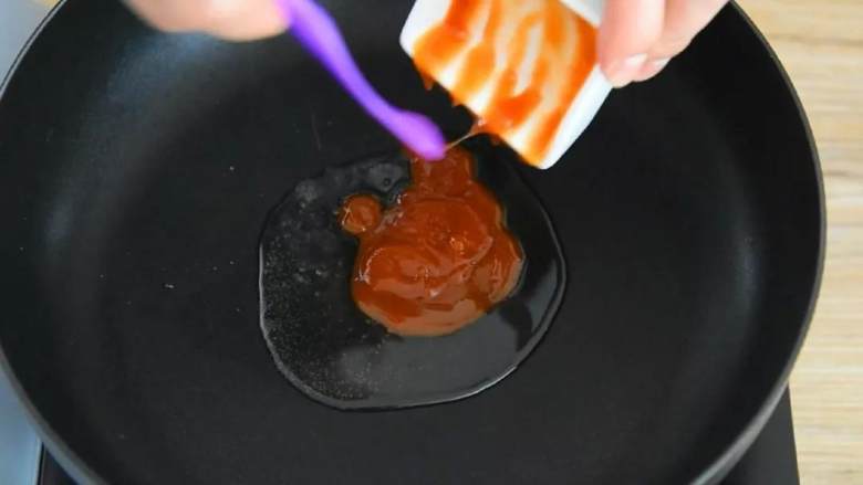 如果你爱吃甜,那么绝对不能错过这道菜,锅里倒入一勺油,放番茄酱滑散。