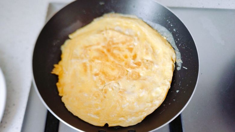 【早餐食】黄瓜鸡蛋豆油卷,当底下那一面成金黄的时候,就可以翻面了,再煎30秒到一分钟,就可以关火了,然后鸡蛋饼切丝,宽窄自己决定。