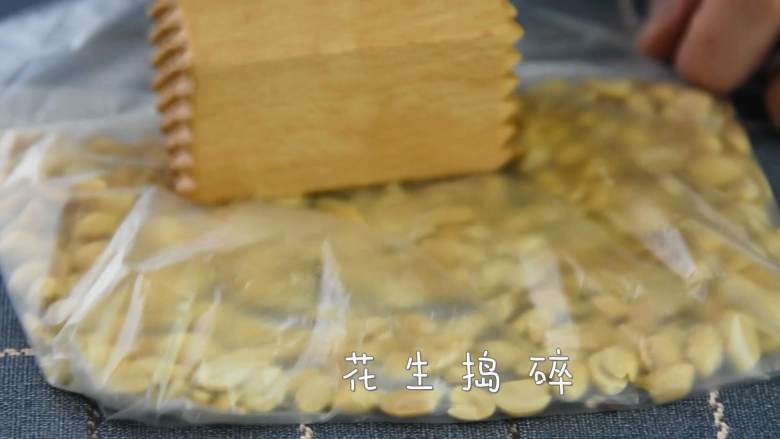 牛轧糖DIY，一起动手做起来,花生仁用锤子慢慢捣碎。