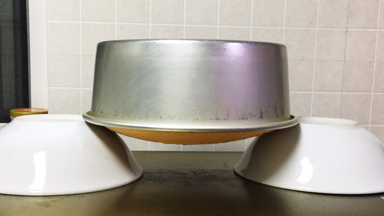 烫面戚风蛋糕,烤完立即倒扣在碗上冷却,3个小时后再脱模。