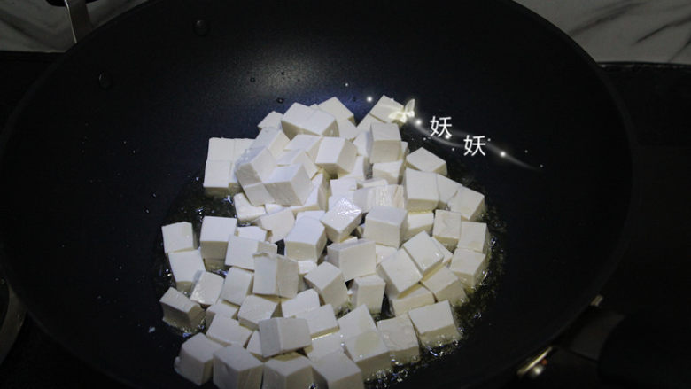 孜然小葱煎豆腐,油锅烧热,下豆腐块煎。丢下去就可以了,不用来回翻动,豆腐嫩,容易碎。