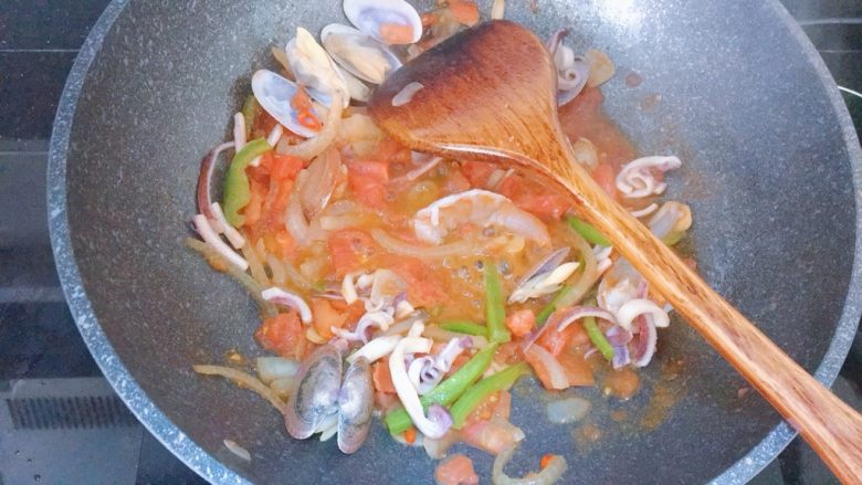 海鲜意大利面,接着把海鲜都倒进去(除了蟹肉棒),翻炒至变色,所有海鲜都裹上汤汁