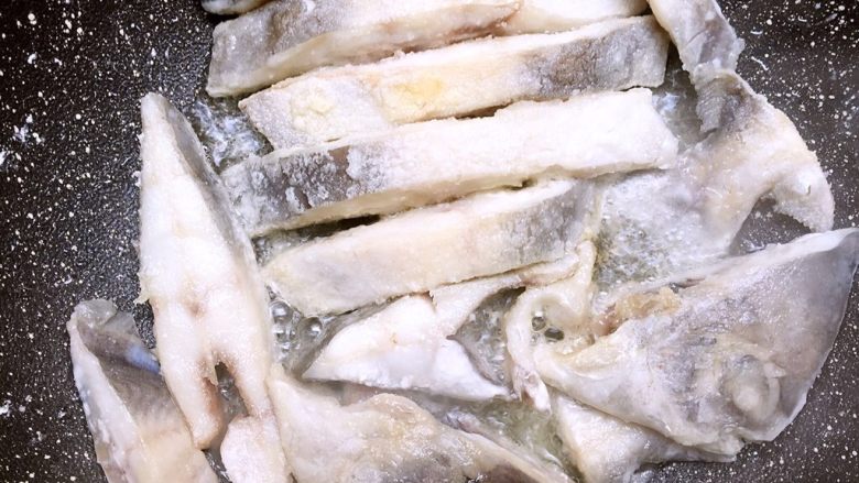 浇汁银鲳鱼,把沾好淀粉鱼块全部放入油锅,小火慢煎