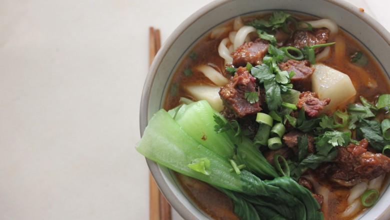 台湾牛肉面,制作一人份牛肉面汤底,一勺卤牛肉的浓汤汁,两勺水,入适量盐调味,入胡萝卜块2块,白萝卜块3块,煮制10分钟。
煮一人份面条至八分熟(中间有一点白芯),过凉水,面条入碗,到入汤底,铺一层牛肉,香菜碎,随意焯些青菜。