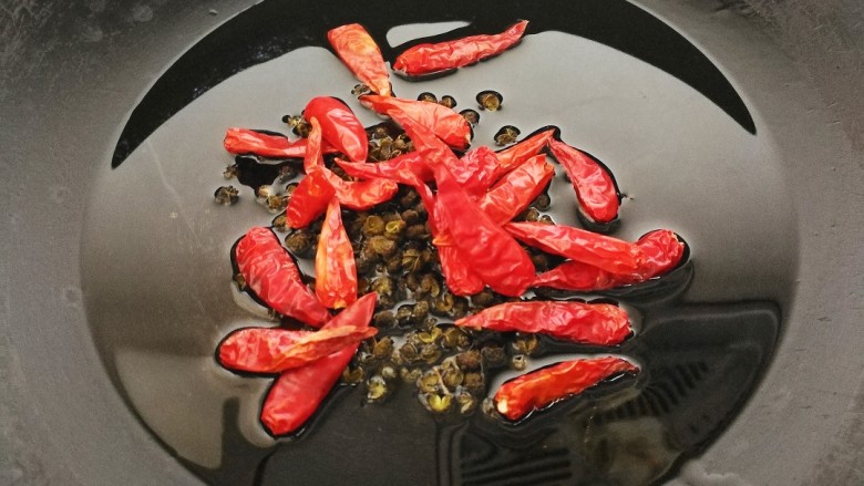 酸辣巴沙鱼,锅烧热,倒入油,八分热时放入花椒和尖辣椒爆香