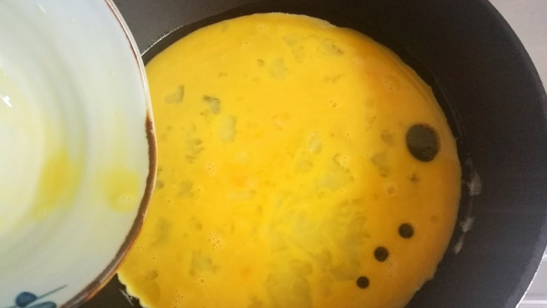 莴苣炒鸡蛋,锅中放油烧热,倒入打散的鸡蛋液。