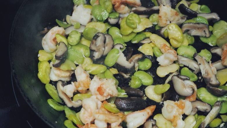 清炒蚕豆香菇虾,在一个炒锅中加入橄榄油,用中高火热油,放入腌好的虾仁翻炒片刻,加入备用的蚕豆和香菇,翻炒均匀,撒上少许盐,炒熟即可。