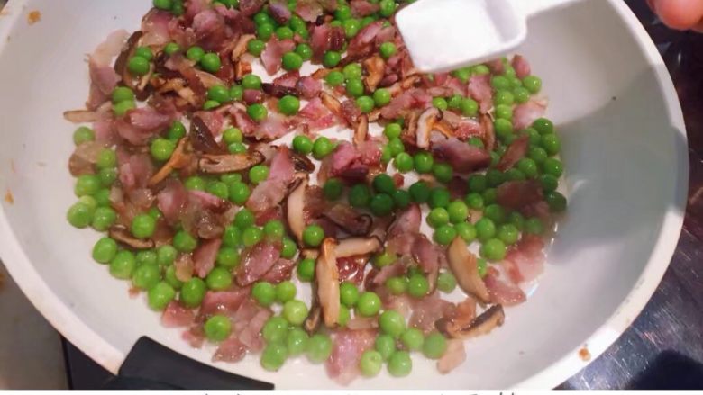 香菇腊肠豌豆蛋炒饭,倒入<a style='color:red;display:inline-block;' href='/shicai/ 148'>豌豆</a>翻炒几分钟,加入约一勺盐