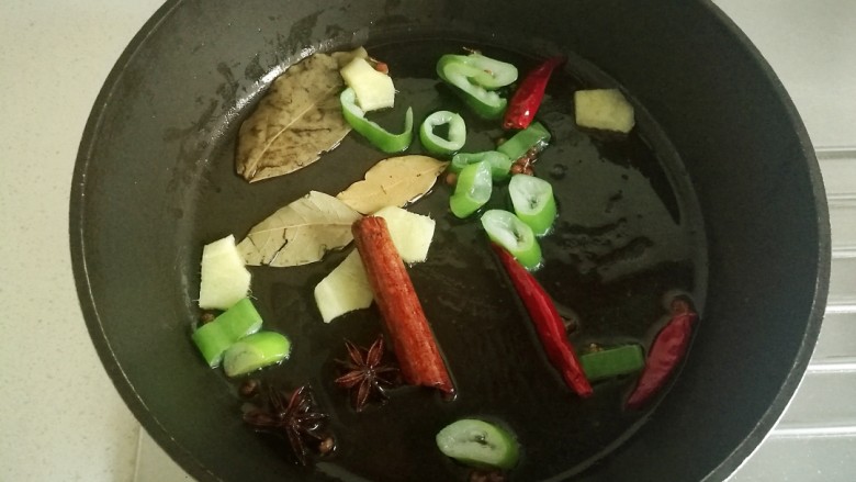糖醋排骨,炒锅里放油,放入葱姜片和八角,花椒,香叶,桂皮和干辣椒炒出香味。