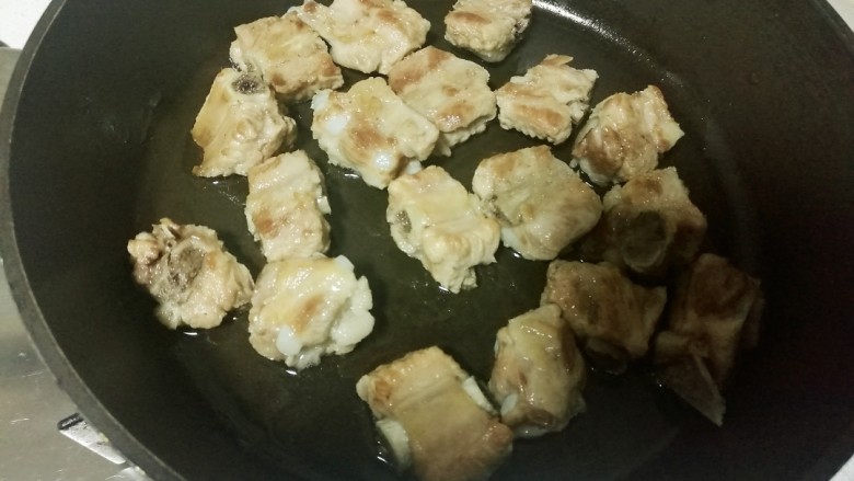 糖醋排骨,煎锅里加适量油,放入排骨段,把两面煎黄。