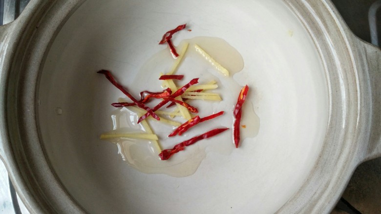 蛋饺娃娃菜粉丝煲,锅内加入5克香油,放入干辣椒和姜丝爆出香味。