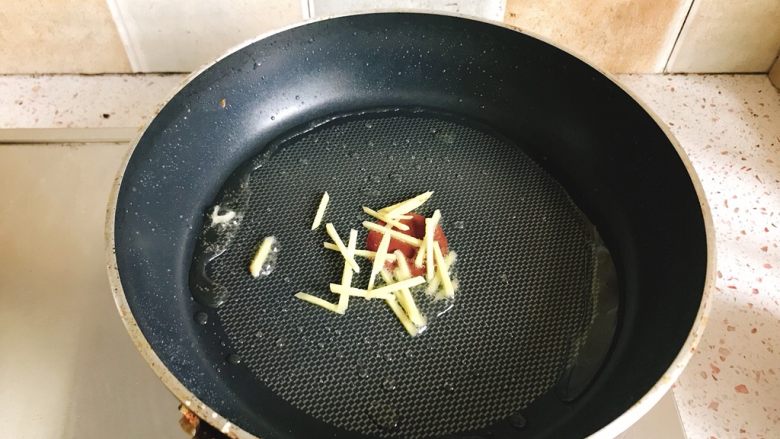 家常香煎豆腐块,平底锅放少量油,加入生姜丝