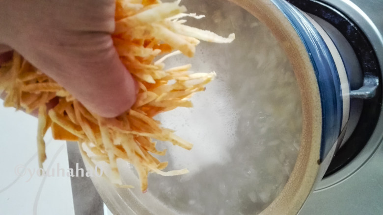 红薯丝粥,煮五分钟后放入地瓜丝,用饭勺搅拌几下,避免沾锅底。