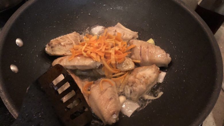 香橙鸡翅,将葱、姜、蒜和橙皮丝倒入油锅中翻炒。