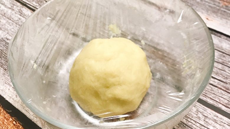 桃花酥,油皮部分材料混合均匀,揉和成团,揉至表面光滑后,覆上保鲜膜,静置半小时