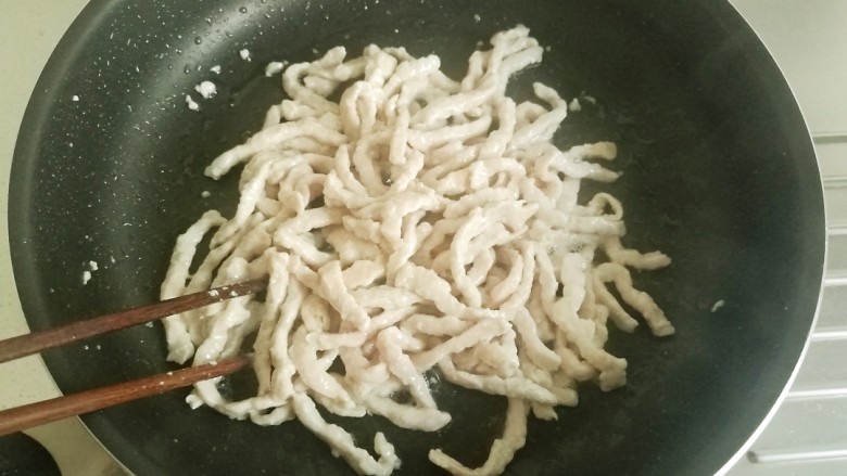鱼香肉丝#,用筷子翻炒,等肉丝变白后盛出备用。