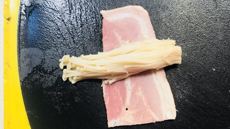 金针菇培根卷,取一小撮金针菇,放于培根上面,卷起培根,用牙签固定