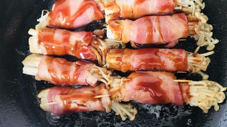 金针菇培根卷,煎至培根各面都焦黄,倒入酱汁