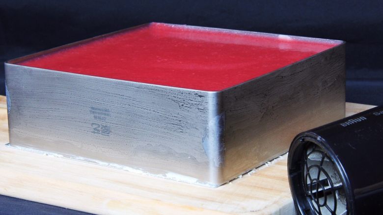 草莓慕斯蛋糕,模具从冰箱中取出,用吹风机热风吹四周。