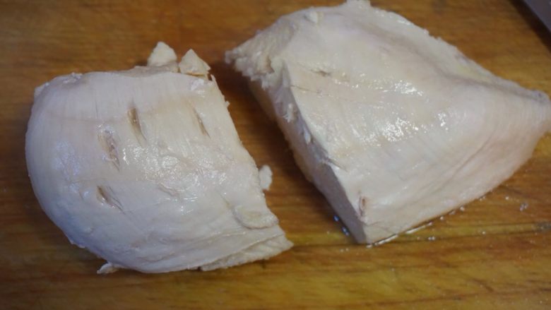 葱椒拌鸡,鸡胸肉煮熟后捞起入冷水泡一下,沥干,顺着肉的纹路来一刀,如图