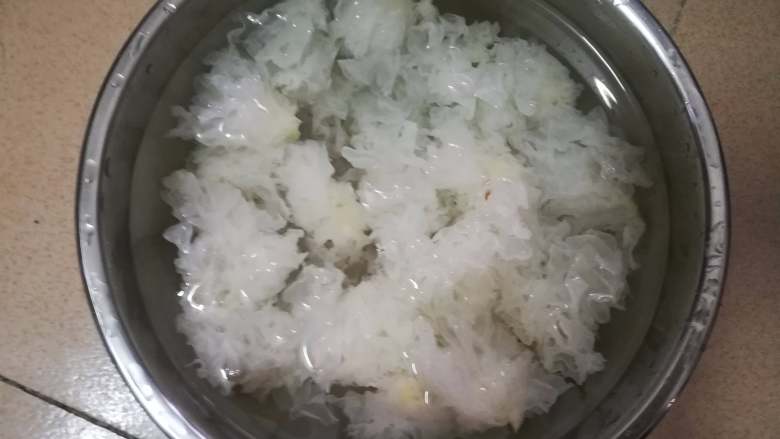 冰糖银耳炖雪梨,摘掉黄色的根蒂部位，撕成小块