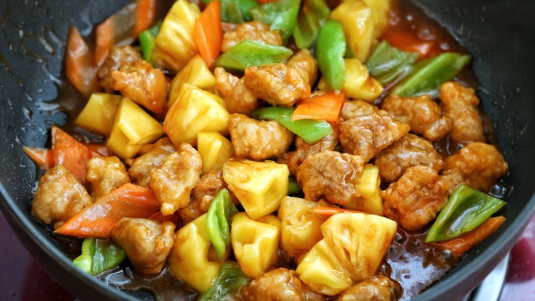 菠萝咕咾肉,倒入调好的酱汁,快速翻炒至食材裹满酱汁关火即可