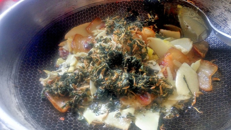 农家干菜油焖春笋,再加入切好的干酸菜一起炒。笋子炒时吃油但不吸油,炒熟之后又会将油“吐”出来一部分,这个时候“吸”油的干菜就将多余的油脂全接收了。