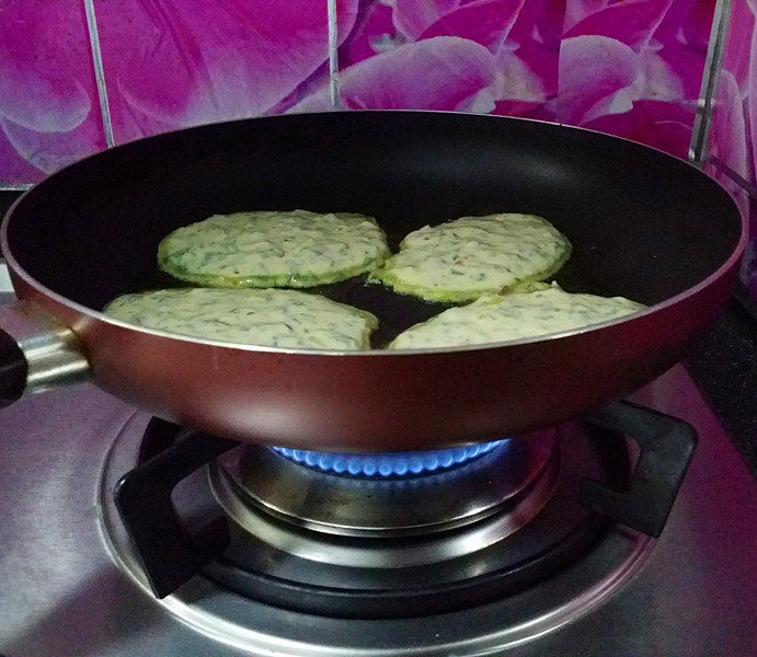马兰头鸡蛋饼,开中小火慢慢煎制,待表面变色四周出现翘边后翻面