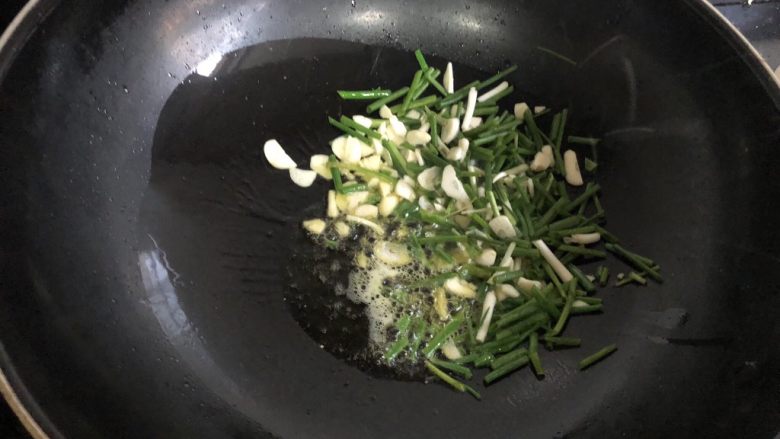 豆瓣酱炒花蛤,锅里烧热放入适量油,油热后放入多点的葱姜蒜爆香。