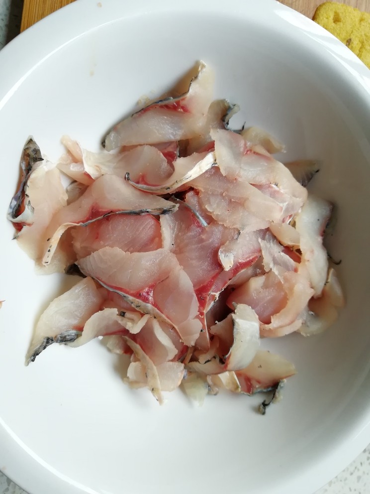 酸菜鱼,两边鱼肉斜刀切片,然后放在水中冲洗,在泡几分钟,把里面的血水全部洗掉