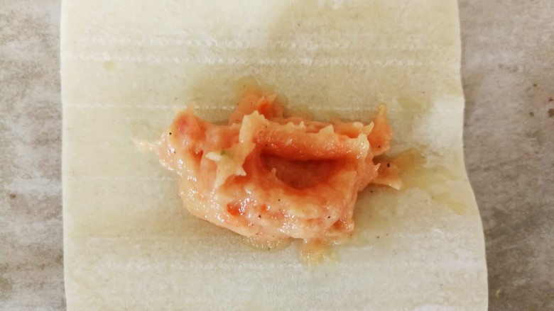 胡萝卜巴沙鱼牛肉小馄饨,取一张馄饨皮,挖适量的馅料放在中间