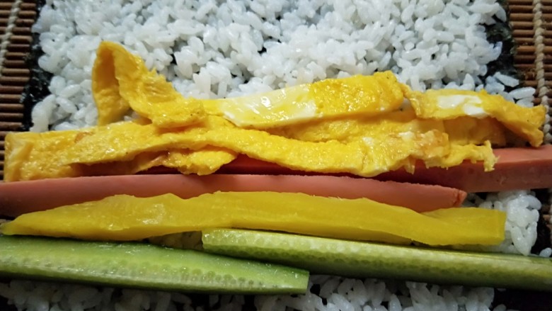 紫菜包饭,放入黄瓜,火腿肠,鸡蛋条。