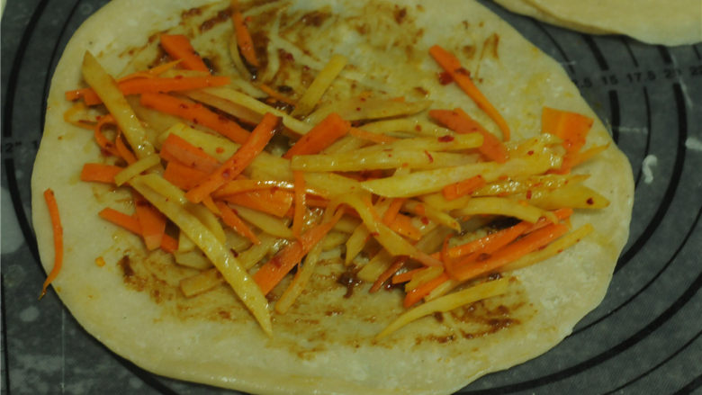 薏米卷饼,蒸好的饼撕开,表面刷上<a style='color:red;display:inline-block;' href='/shicai/ 705'>豆瓣酱</a>,将炒熟的食材摆放在上面,