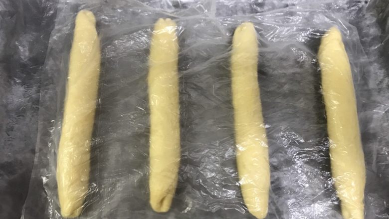 桃李毛毛虫奶油面包,四个都卷好,盖保鲜膜醒发5分钟。
