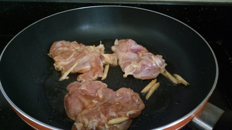 日式照烧鸡腿,平底锅加热,放点油姜丝炒香,将腌制好的鸡腿肉下锅煎,鸡皮的一面向下。