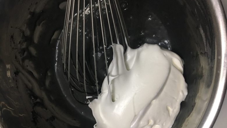 龙猫戚风,取一刮刀蛋白霜加入蛋黄糊,不规则拌匀。