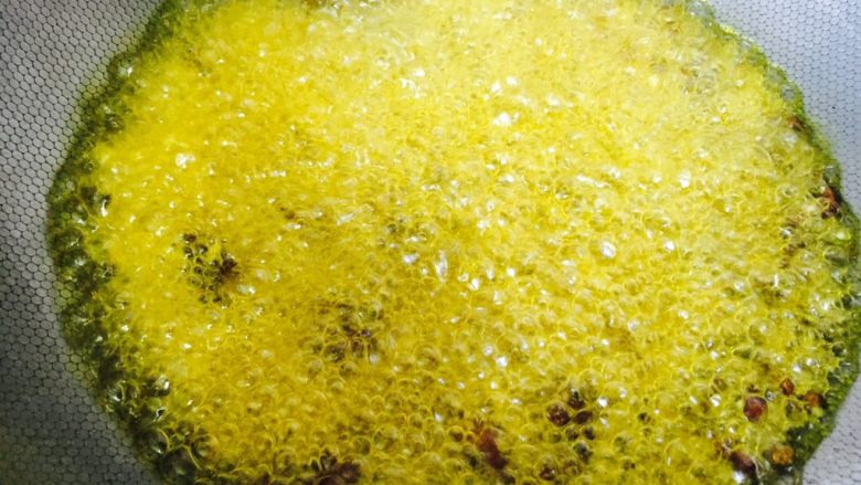 沸腾鱼,待香料熬至快要变色时,倒入姜丝、花椒粒