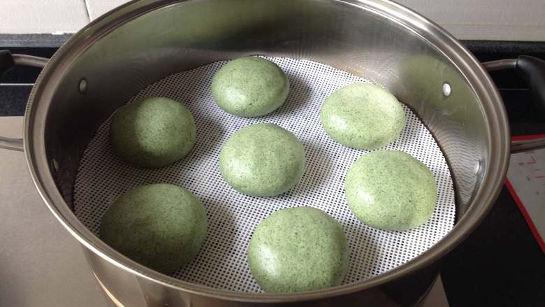 清明粑,放进蒸锅里(蒸锅中事先垫上不粘垫,或在每个饼的下面垫上菜叶防粘),大火将水烧开,转中火蒸12分钟