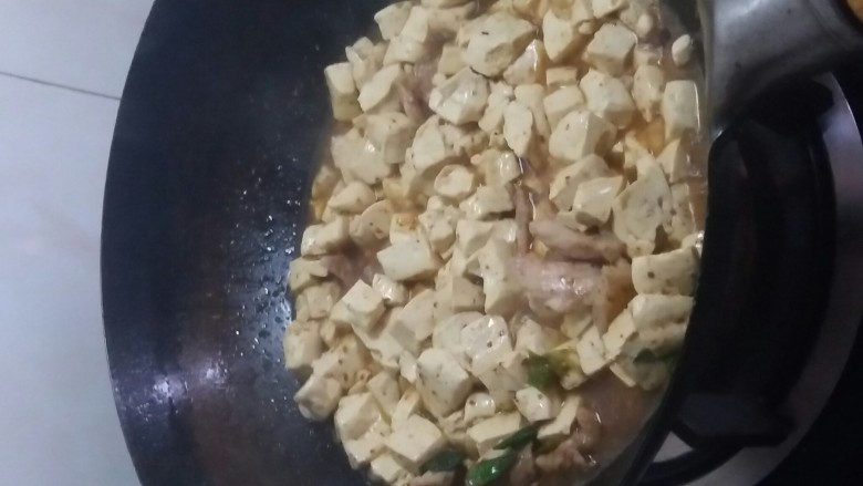 宅吃辣豆腐,把豆腐倒入进去，用铲子翻炒。依然大火。