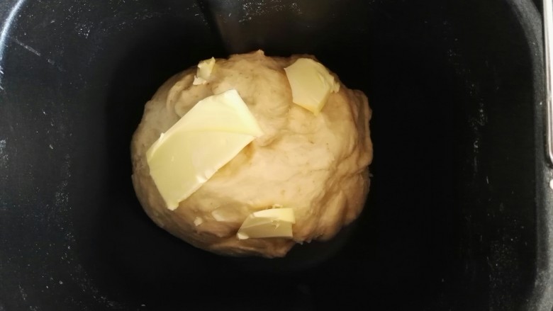 外表金黄内里柔软的全麦吐司面包,当面团有筋性的时候,加入软化的黄油,继续揉面。