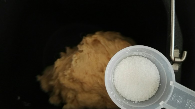 外表金黄内里柔软的全麦吐司面包,当面粉成团时,加入盐,这个时候可以根据面团的软硬度,将剩余的清水加入面包机中,继续揉面。