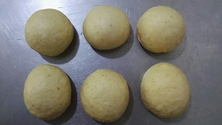 外表金黄内里柔软的全麦吐司面包,将面团从盆中取出,用手挤压将气体排出后,将面团分成6个小面团,揉成圆形盖上保鲜膜静置10分钟。